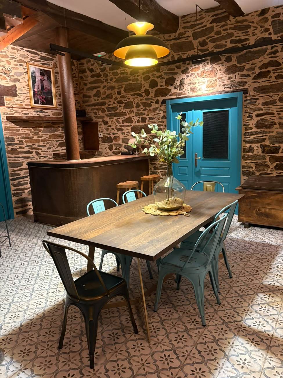 Comedor de Casa Fede con vigas de madera y piedra vista